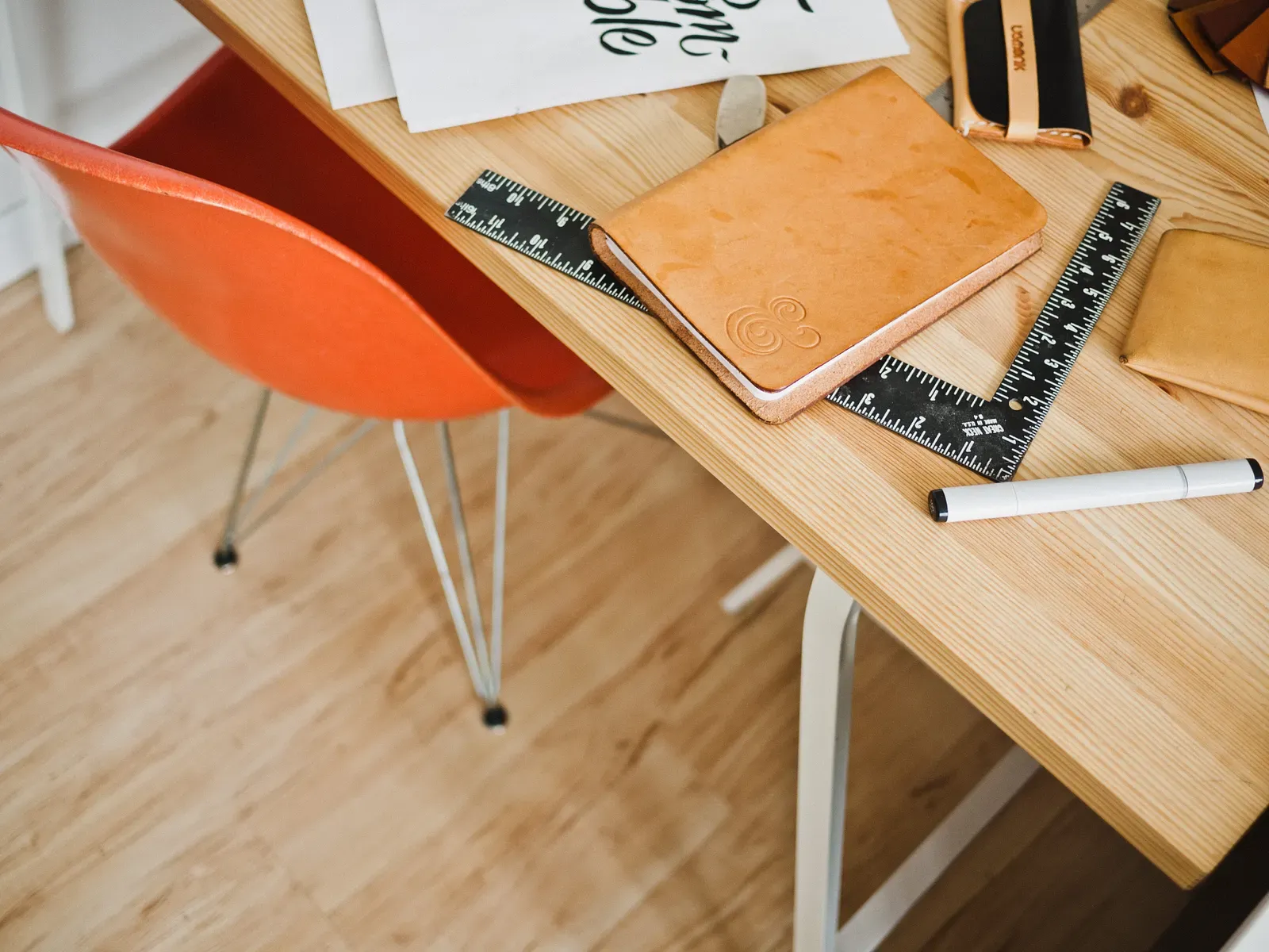 “A designers room with a polished furniture and a notebook, carpenter squares, a ruler and a pen for sketching and study.” by Jeff Sheldon on Unsplash