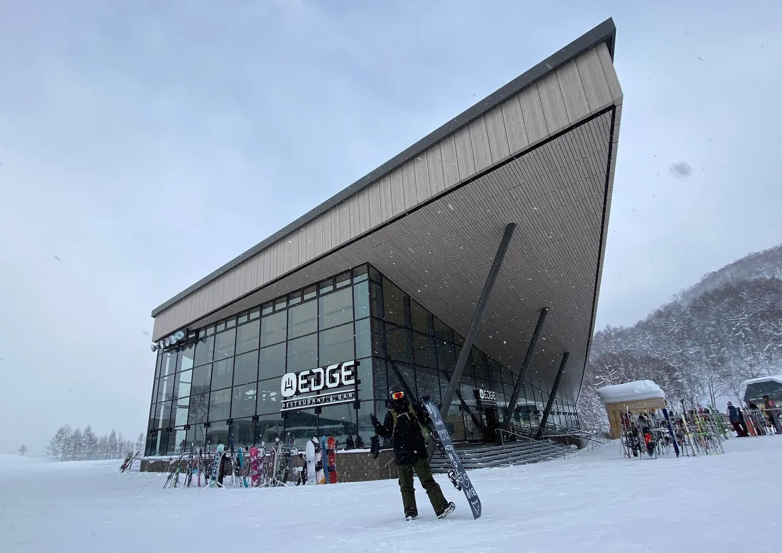 在下雪的日本滑雪場抱著滑雪板留影