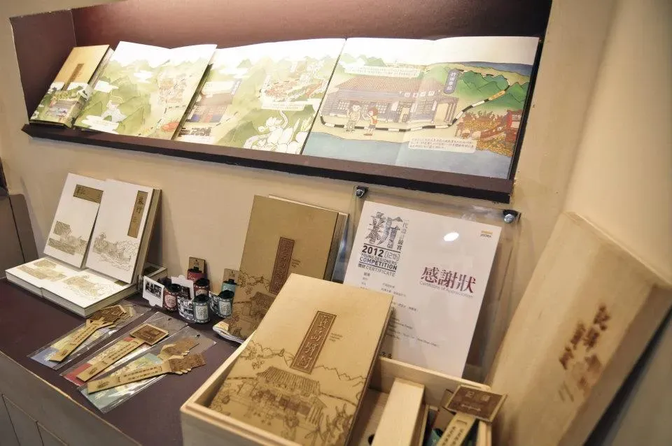 畢業製作展出的插畫書與木盒作品，旁邊擺著新一代設計展感謝狀